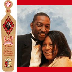 a man and woman are posing for a photo with a wine bottle in the background