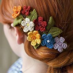 a woman with red hair wearing a crocheted flower clip