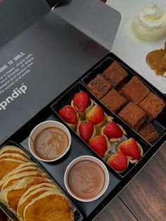 an assortment of desserts and pastries are displayed in a box on a table