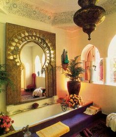 a bath room with a large mirror and a potted plant on the side of it