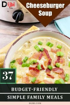 a bowl of cheeseburger soup with bacon and green onions in it on a wooden table