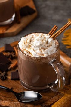 hot chocolate drink with whipped cream and cinnamon sticks