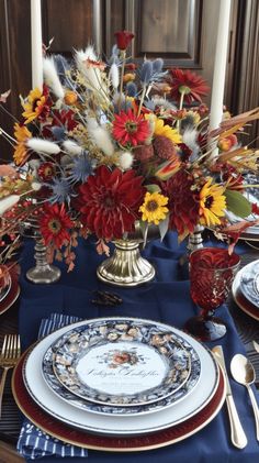 a table set with plates, silverware and flowers