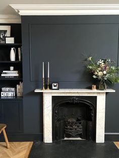 a living room with a fire place and bookshelves on the wall next to it