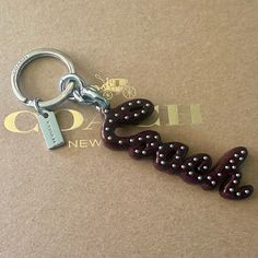 a keychain with the word love spelled out in black and white beads on it