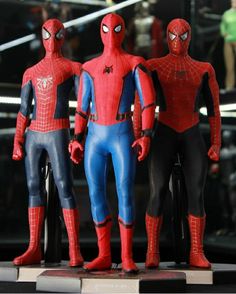 three spider - man figurines are on display