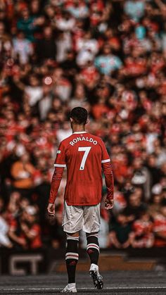 a soccer player is standing in front of an audience with his foot on the ground