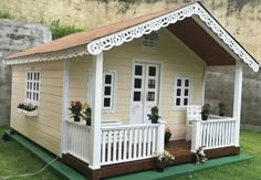 a small wooden house sitting on top of a lush green field