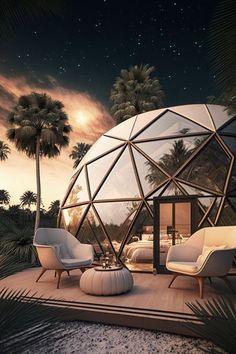 a glass dome house with palm trees in the background and an outdoor seating area for two