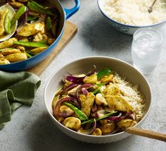 a bowl filled with rice and vegetables next to another bowl full of chicken stir fry