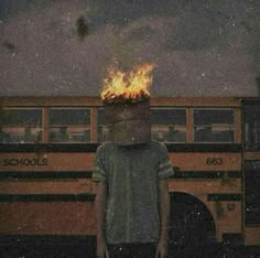 a person standing in front of a school bus with fire coming out of their head