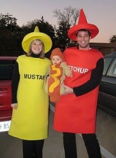 two people dressed up in costumes standing next to each other near a parked car, one holding a hot dog and the other holding a stuffed toy