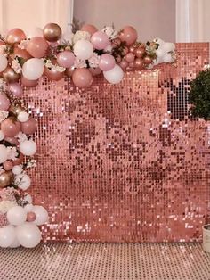 pink and white balloons are hanging from the back of a sequin - embellished backdrop