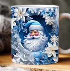 a coffee mug with a santa clause on it sitting on top of a wooden table