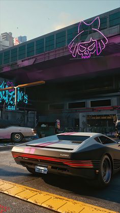 a car parked in front of a building with neon signs on it's side