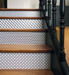 the stairs are painted with black and white geometric designs on them, as well as wood handrails