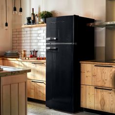 a black refrigerator freezer sitting inside of a kitchen