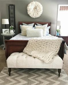 a bed with pillows and blankets on top of it in a room that has carpeted floors