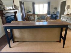 a living room filled with furniture and a large wooden table in the middle of it