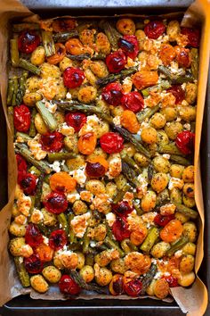 a casserole dish with tomatoes, green beans, and other vegetables in it