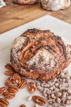 a loaf of bread sitting on top of a counter next to pecans and nuts