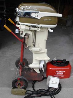 a boat engine sitting on top of a red cart