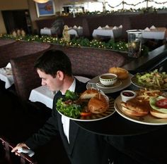 a man in a tuxedo serving food at a restaurant