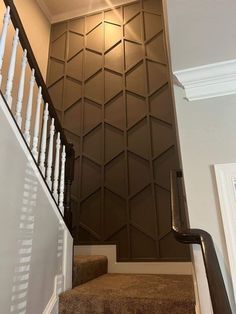 stairs leading up to the second floor with decorative wall paneling on each handrail