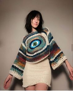 a woman wearing a sweater with an eye on it