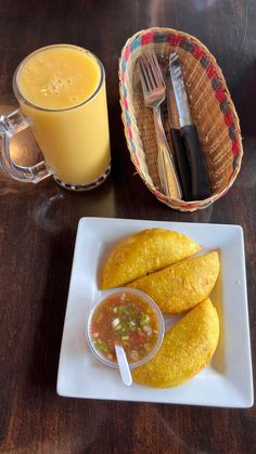 some food is sitting on a plate next to a glass of orange juice