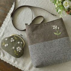 a purse sitting on top of a table next to flowers