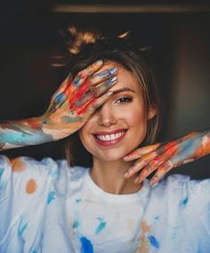 a woman with painted hands covering her eyes