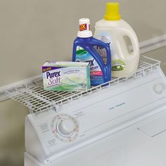 a washer and detergent sitting on top of a dryer