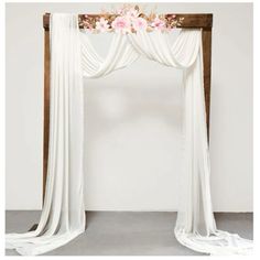 a white drape with pink flowers on the top and bottom, hanging from it's sides