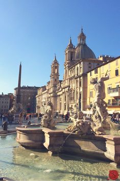 the fountain is surrounded by statues and buildings