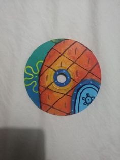 an orange and blue object on top of a white sheet with a hole in the middle