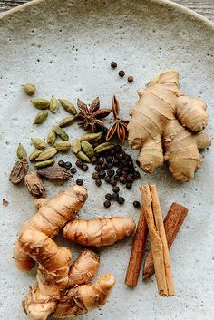 an assortment of spices on a plate with ginger, cardamoa, cinnamon and cloves