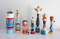 several wooden toy figurines sitting on top of a white table next to each other