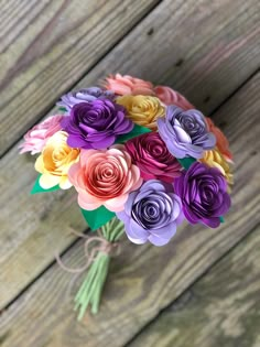 a bouquet of colorful paper flowers sitting on top of a wooden table