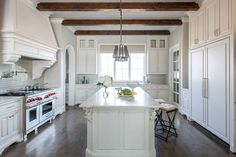 a large kitchen with white cabinets and an island