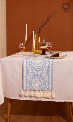 the table is set with wine glasses, candles and other things to drink on it