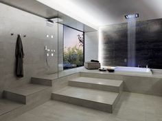 a bathroom with steps leading up to the bathtub and shower area that is illuminated by recessed lighting