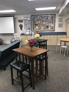 a room with tables, chairs and pictures on the wall