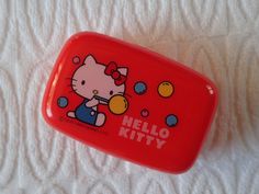 an orange hello kitty case sitting on top of a white sheet with bubbles in it