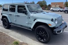 a light blue jeep parked in a parking lot