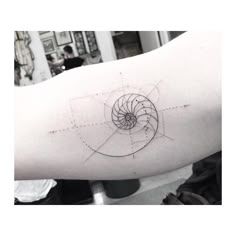 a person's arm with a tattoo on it that has an image of a spiral