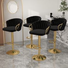 three black velvet bar stools with gold legs in front of a white marble floor