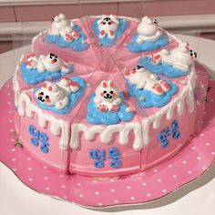 a pink cake with white frosting and blue decorations