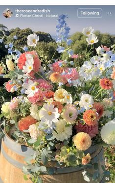 a wooden barrel filled with lots of flowers