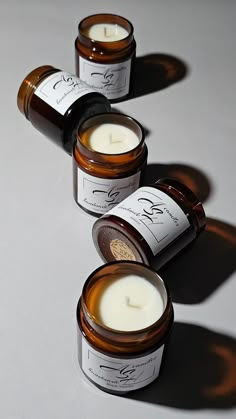 three candles sitting next to each other on top of a white surface with one candle in the middle